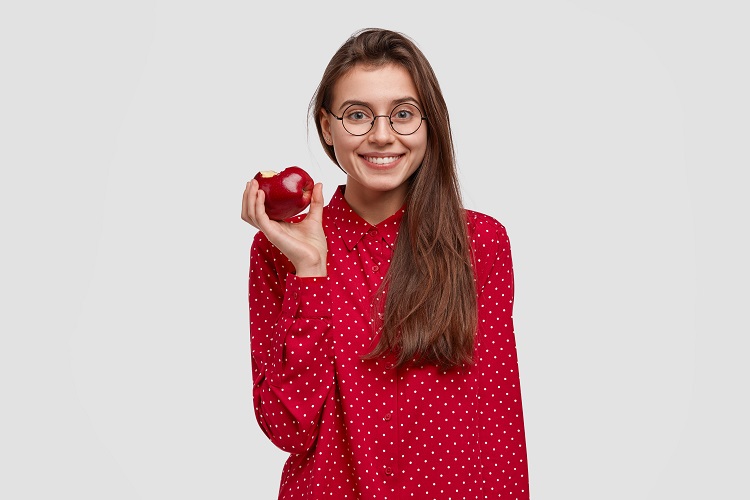 Mujer comiendo una manzana.
